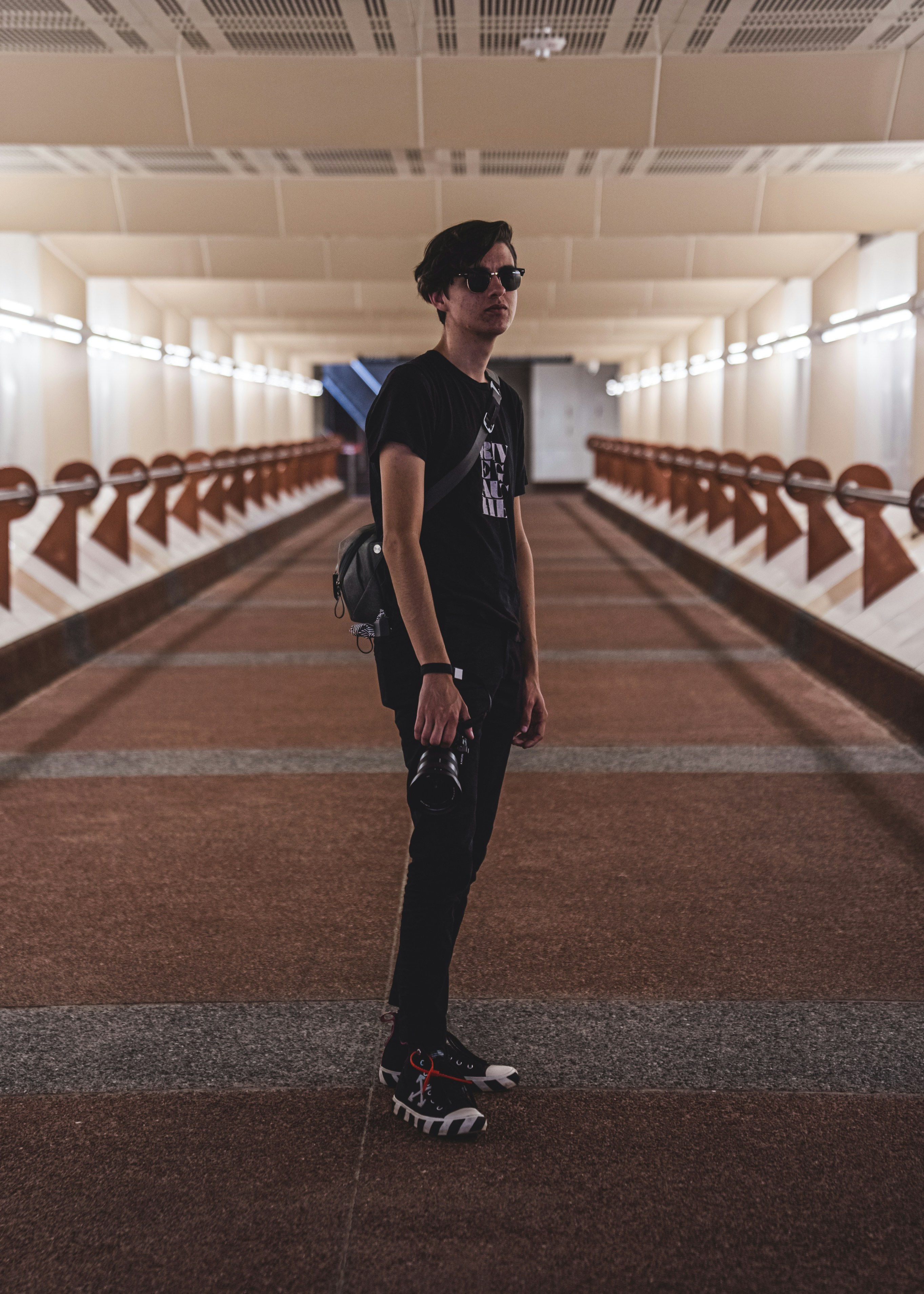 a man standing in a hallway with a backpack