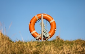 an orange life preserver hanging from a pole