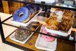 A colorful display of assorted pastries and muffins on a glass counter at Sugar and Spice Coffee.