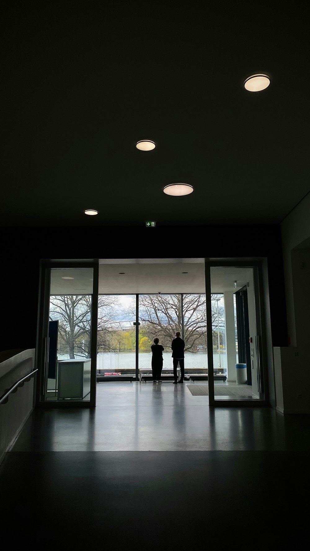 a couple of people standing in front of a glass door