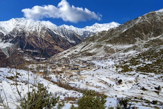 a snow covered mountain with a village in the distance