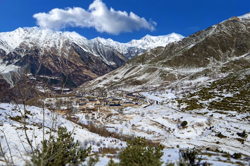 a snow covered mountain with a village in the distance