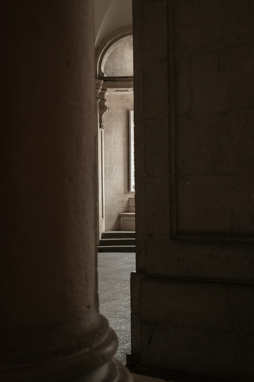 a hallway with columns and a clock on the wall