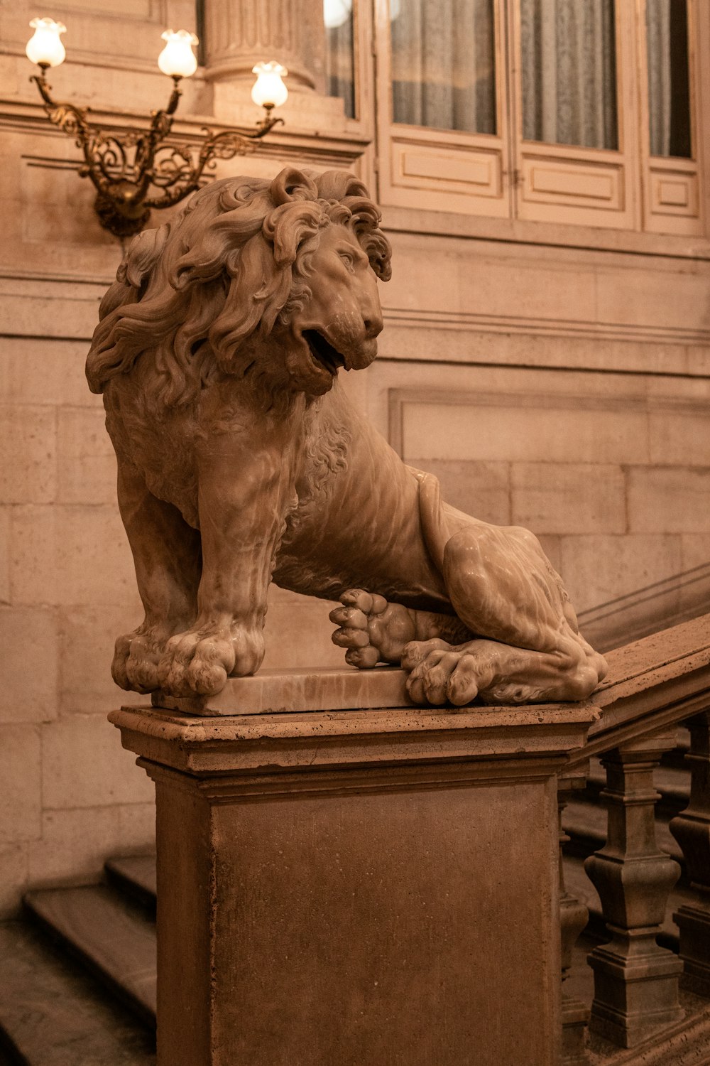 a statue of a lion sitting on top of a wooden bench