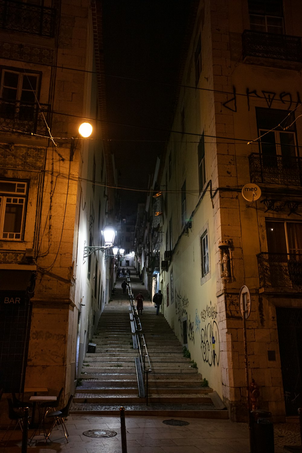 a dark alleyway with stairs leading up to a building