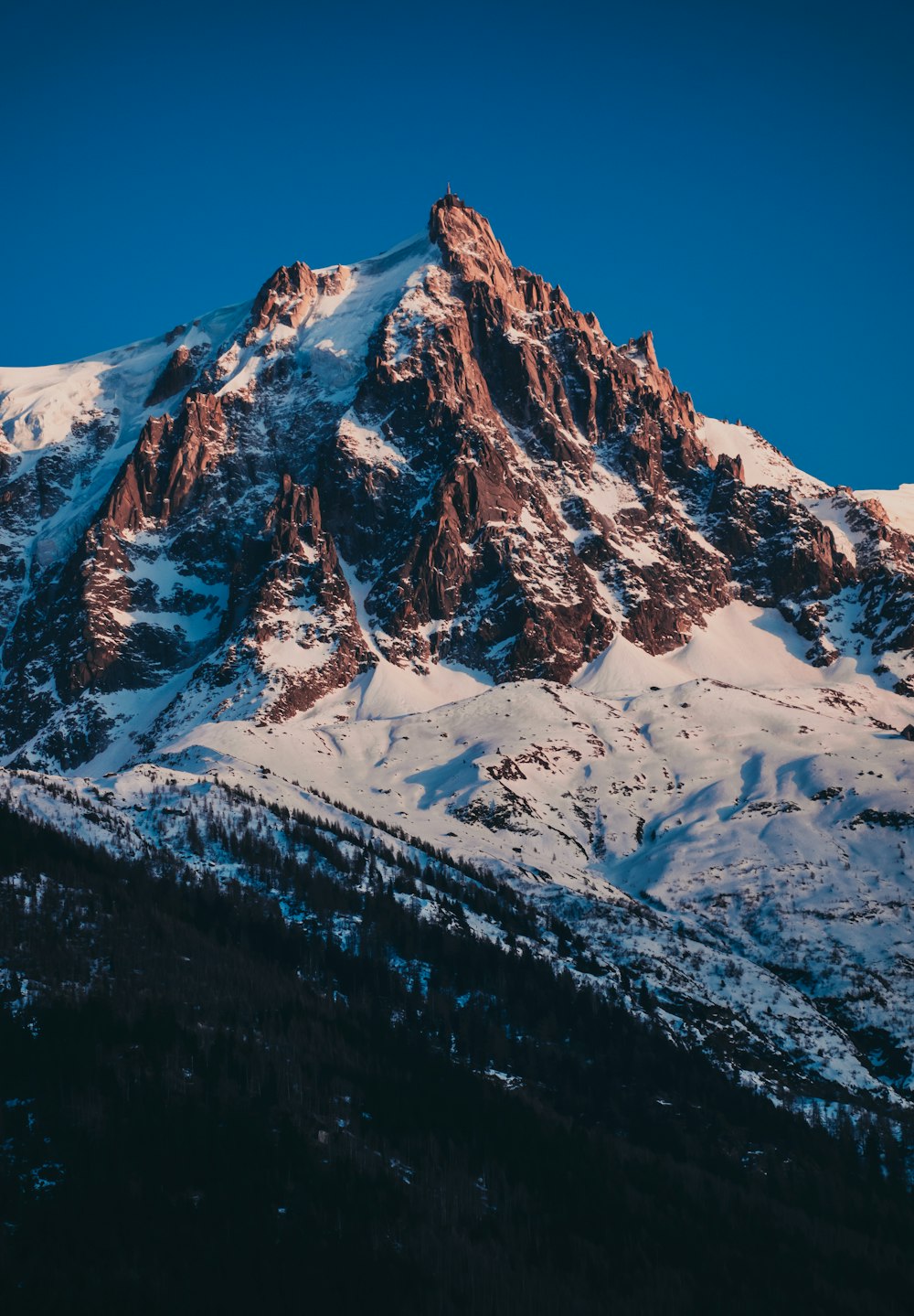 a snow covered mountain with a blue sky in the background