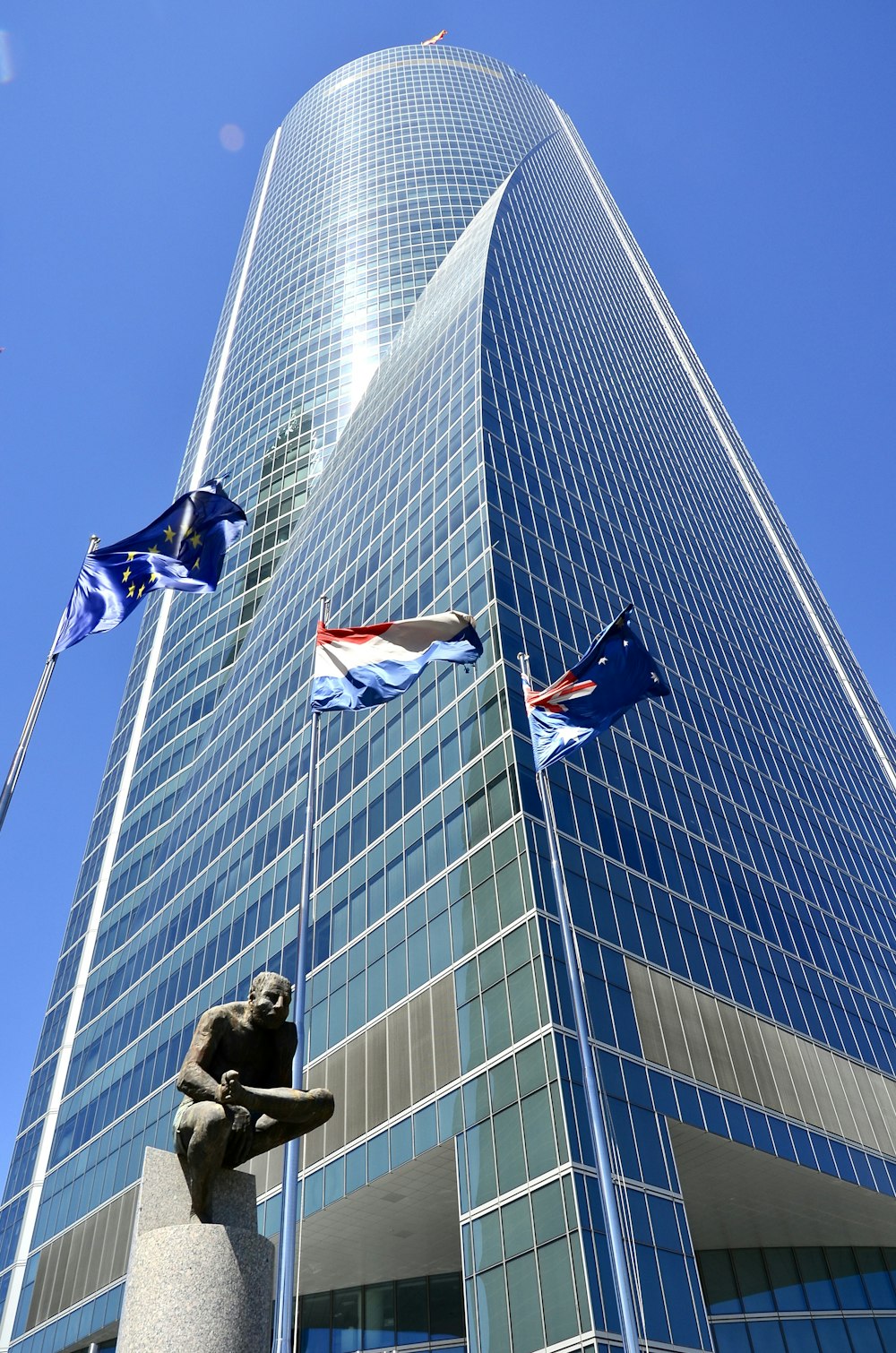 Un edificio alto con una estatua frente a él