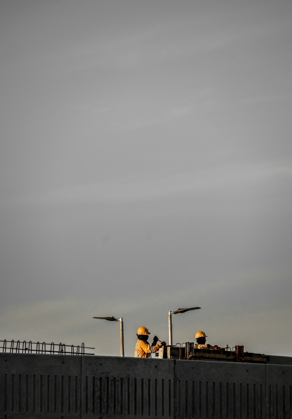 a couple of street lights sitting on top of a cement wall