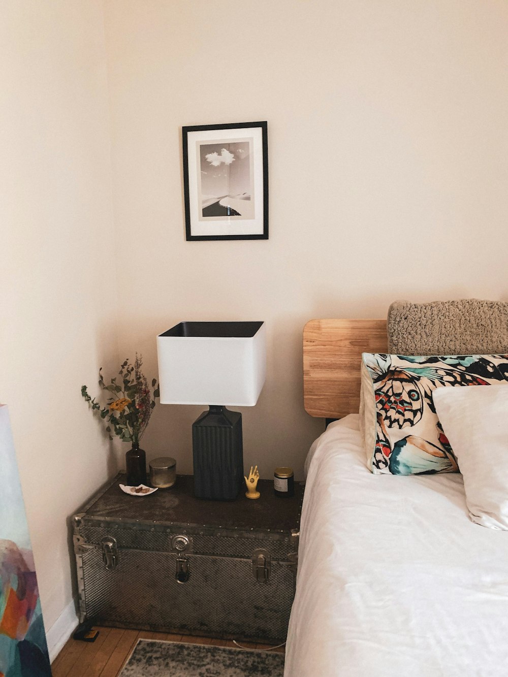 a bedroom with a bed, nightstand, and picture on the wall