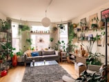 a living room filled with lots of plants and furniture