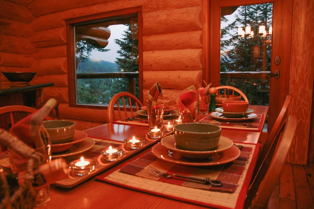 une table de salle à manger avec des couverts et des bougies