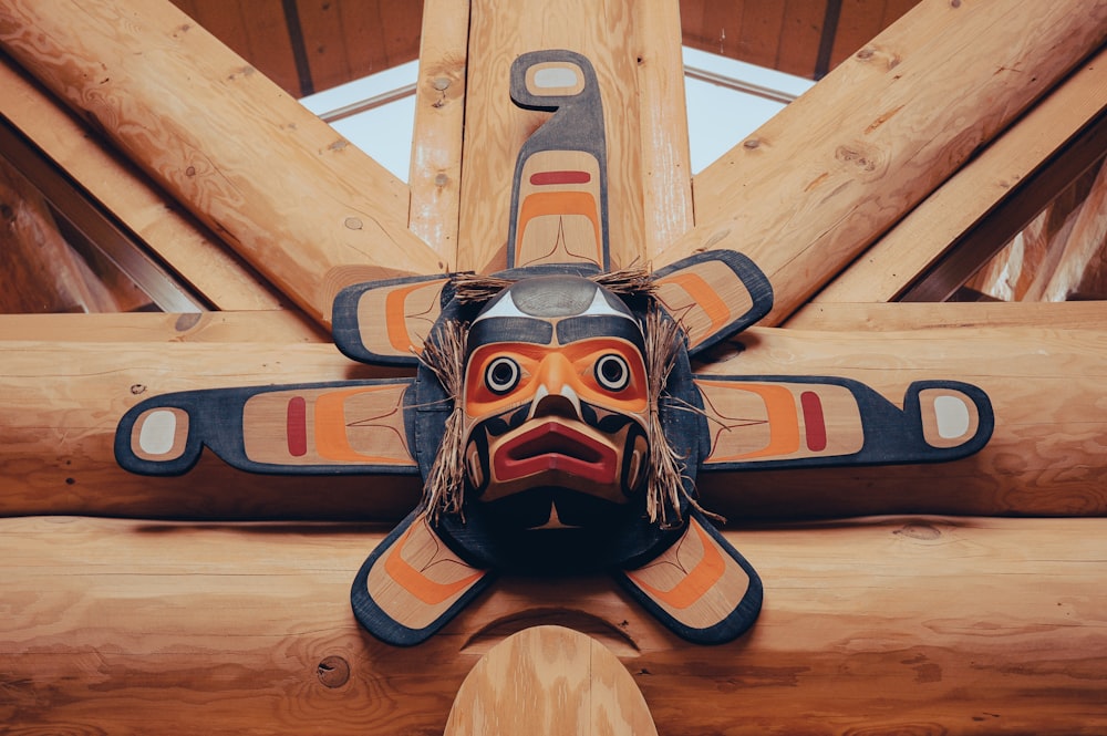 a close up of a wooden sculpture of a person wearing a mask