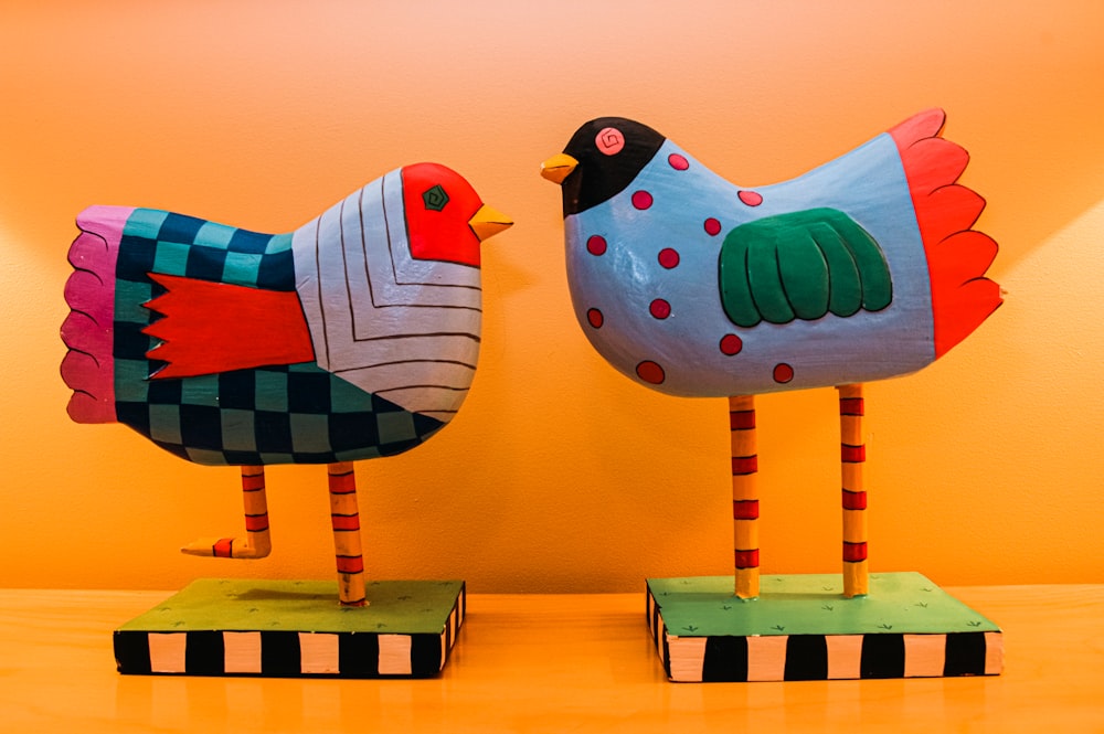 a couple of wooden birds sitting on top of a table