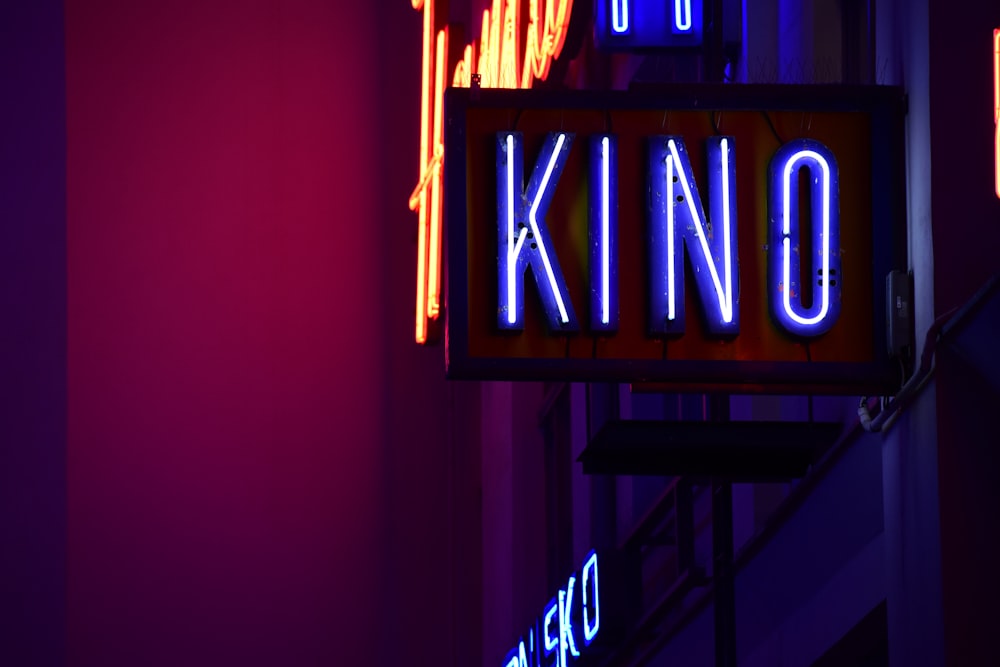 a neon sign hanging from the side of a building