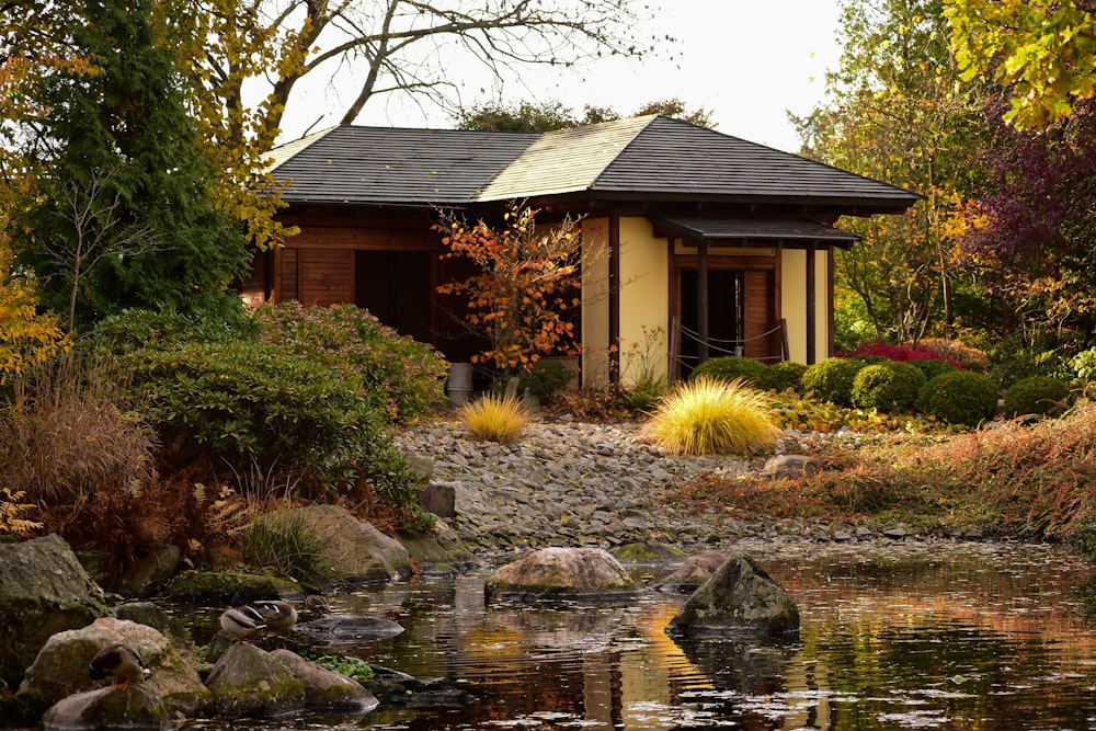 a small house with a pond in front of it