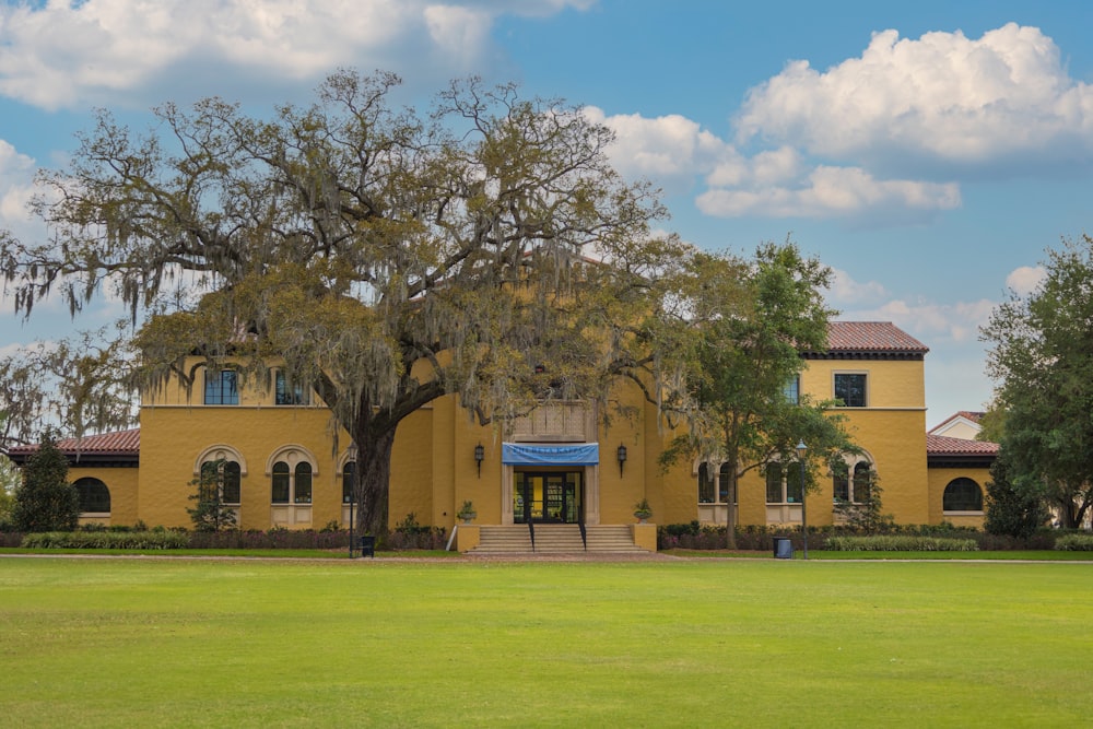 a large yellow building with a large tree in front of it