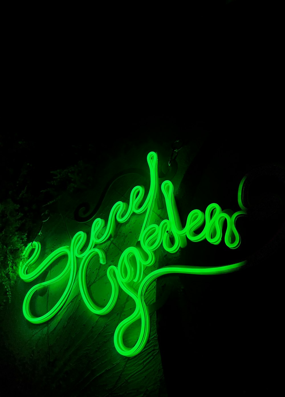 A neon green neon sign on a black wall photo – Free Neon Image on