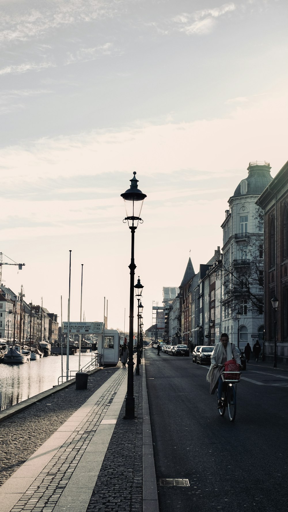 a person riding a bike down a street next to a body of water