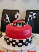 A race car party corner with checkered flags, mini race tracks, and car-shaped snacks.
