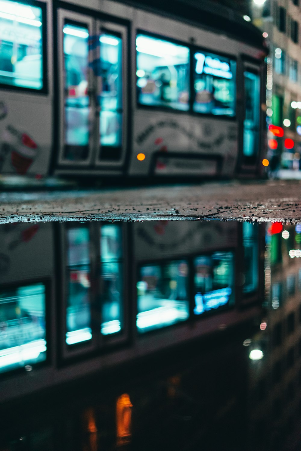 a reflection of a bus in a puddle of water