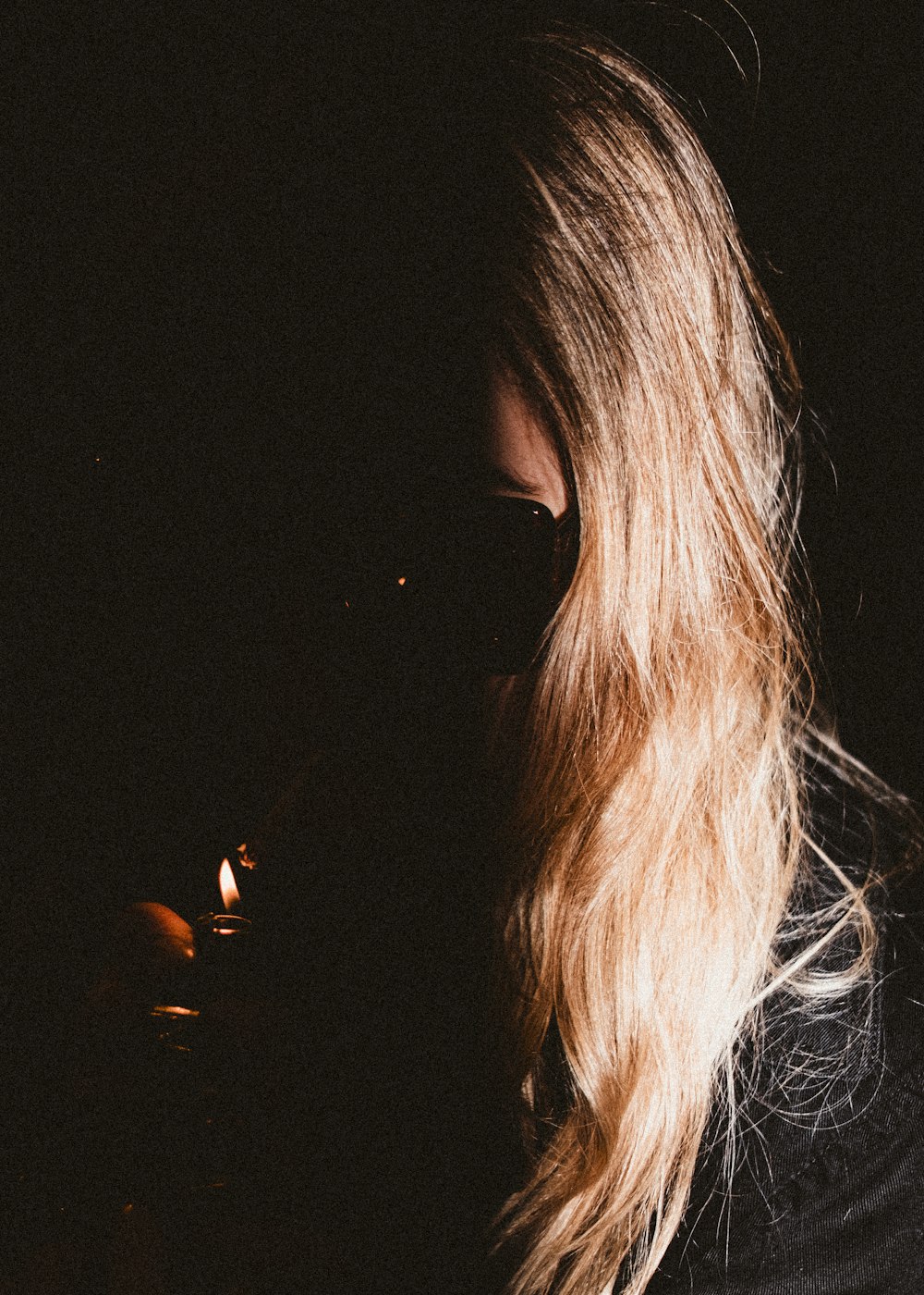 a woman with long blonde hair and dark glasses