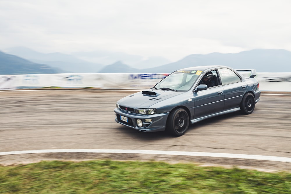 a car driving on a track with mountains in the background