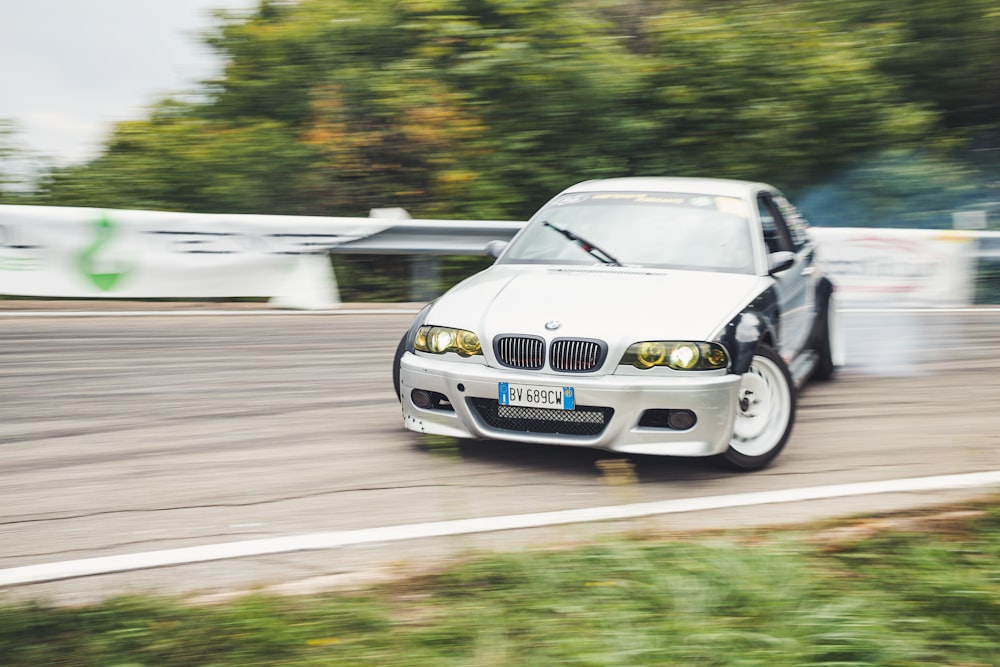 a white car driving down a race track