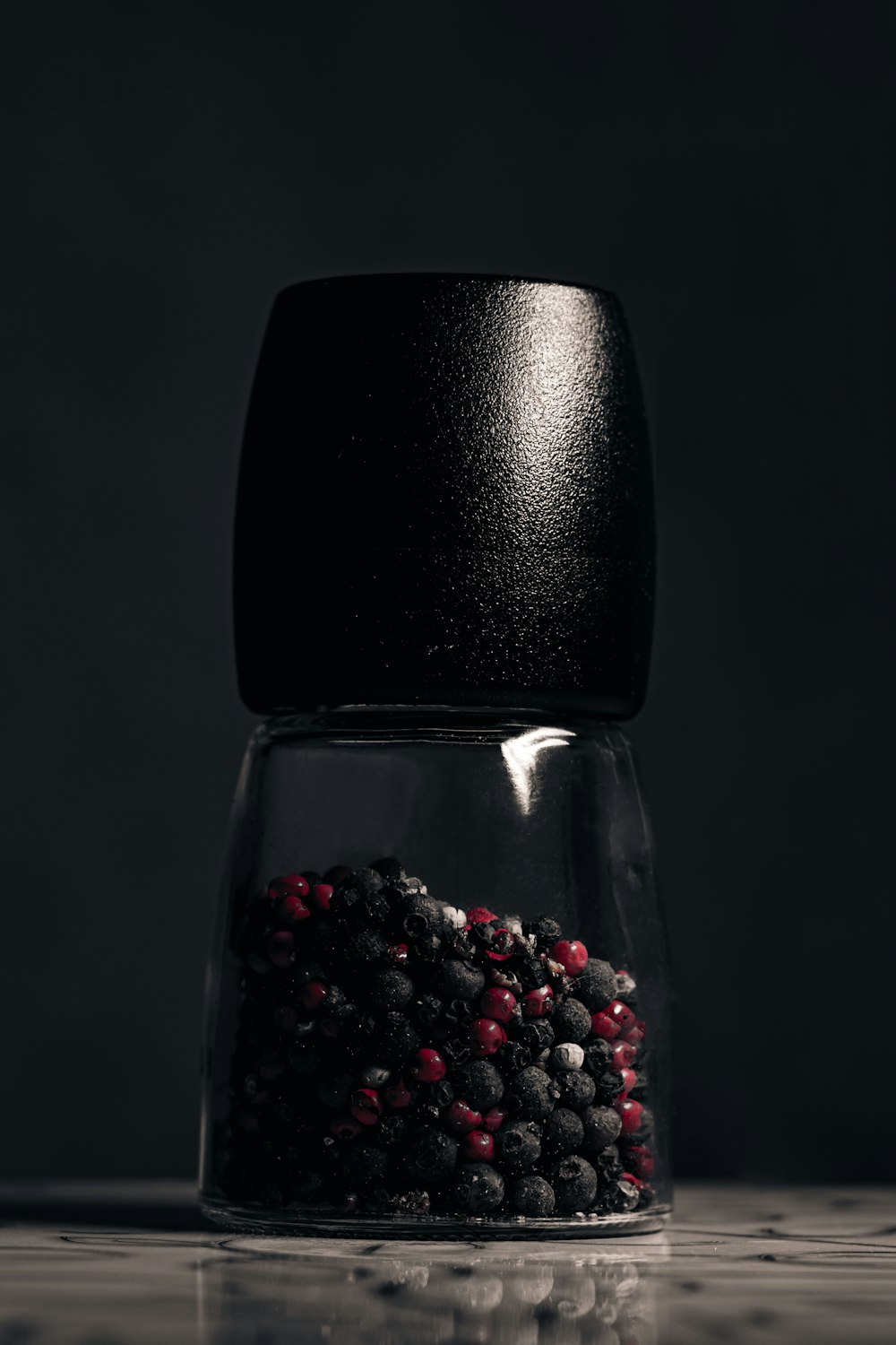 a glass jar filled with black and red food