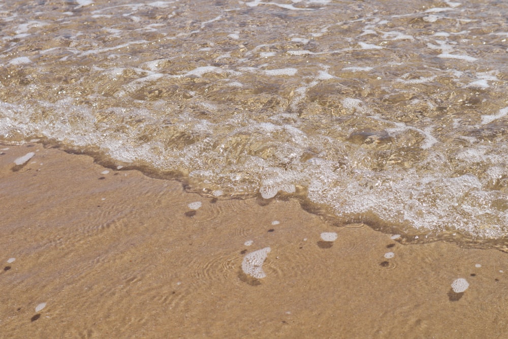 a beach with a wave coming in to shore