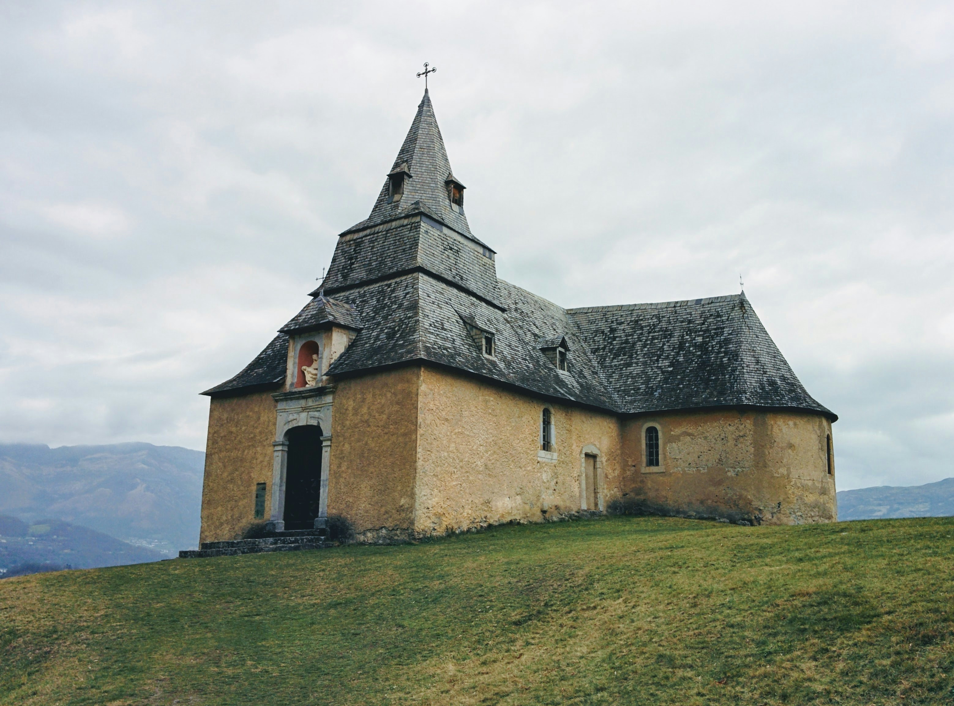 an old church with a steeple on a hill
