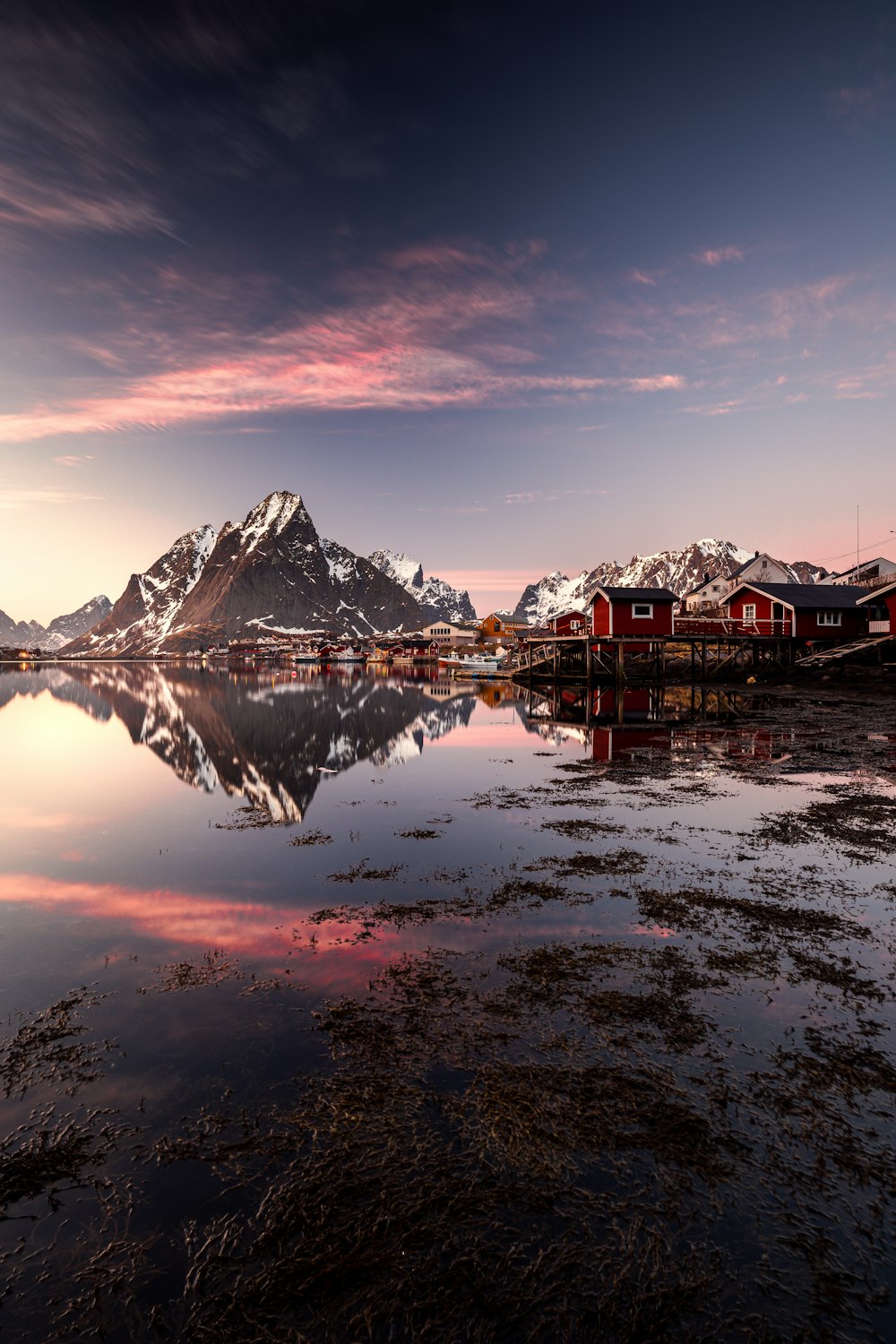 a mountain range is reflected in the still water of a lake