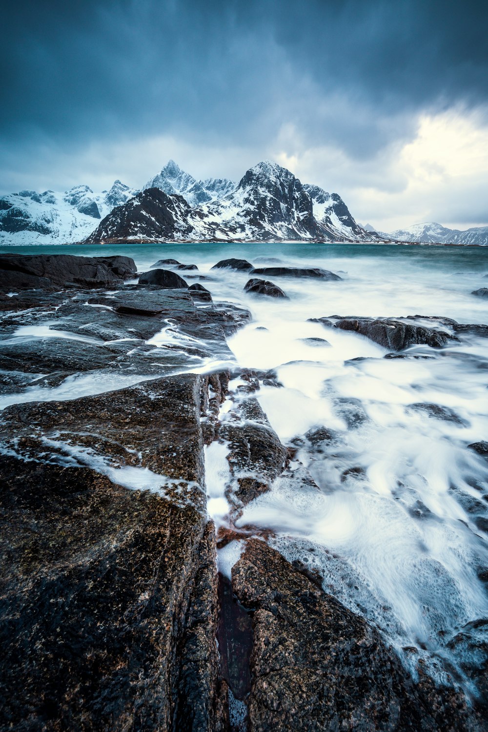 a rocky beach with a mountain in the background