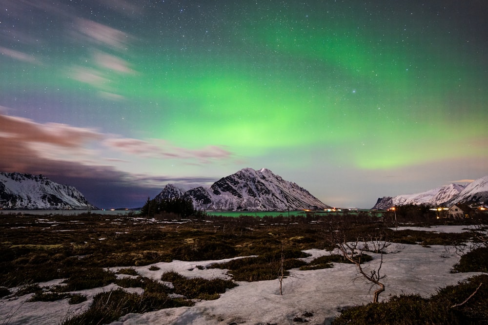 a green and purple aurora over a mountain range