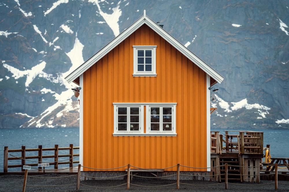 an orange building with a white window and a fence