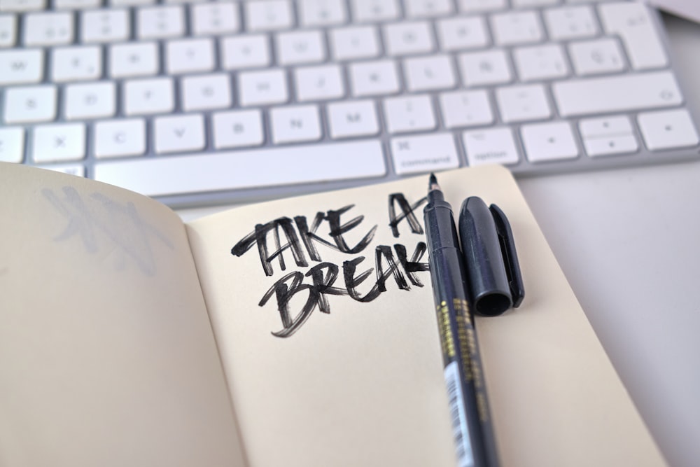 a notebook with some writing on it next to a keyboard