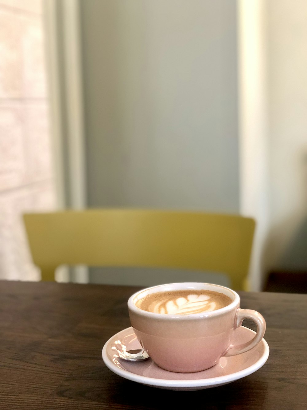 a cup of coffee sitting on top of a wooden table