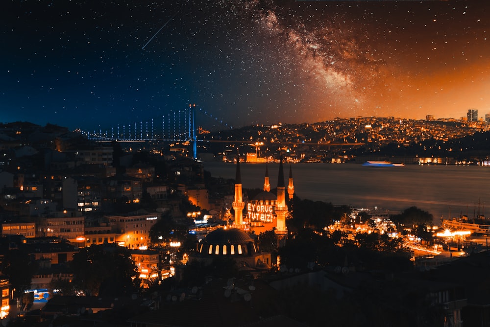 a night time view of a city with a bridge in the background