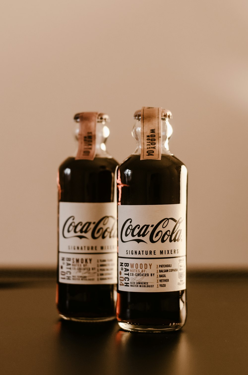 two bottles of coca cola sitting on top of a table