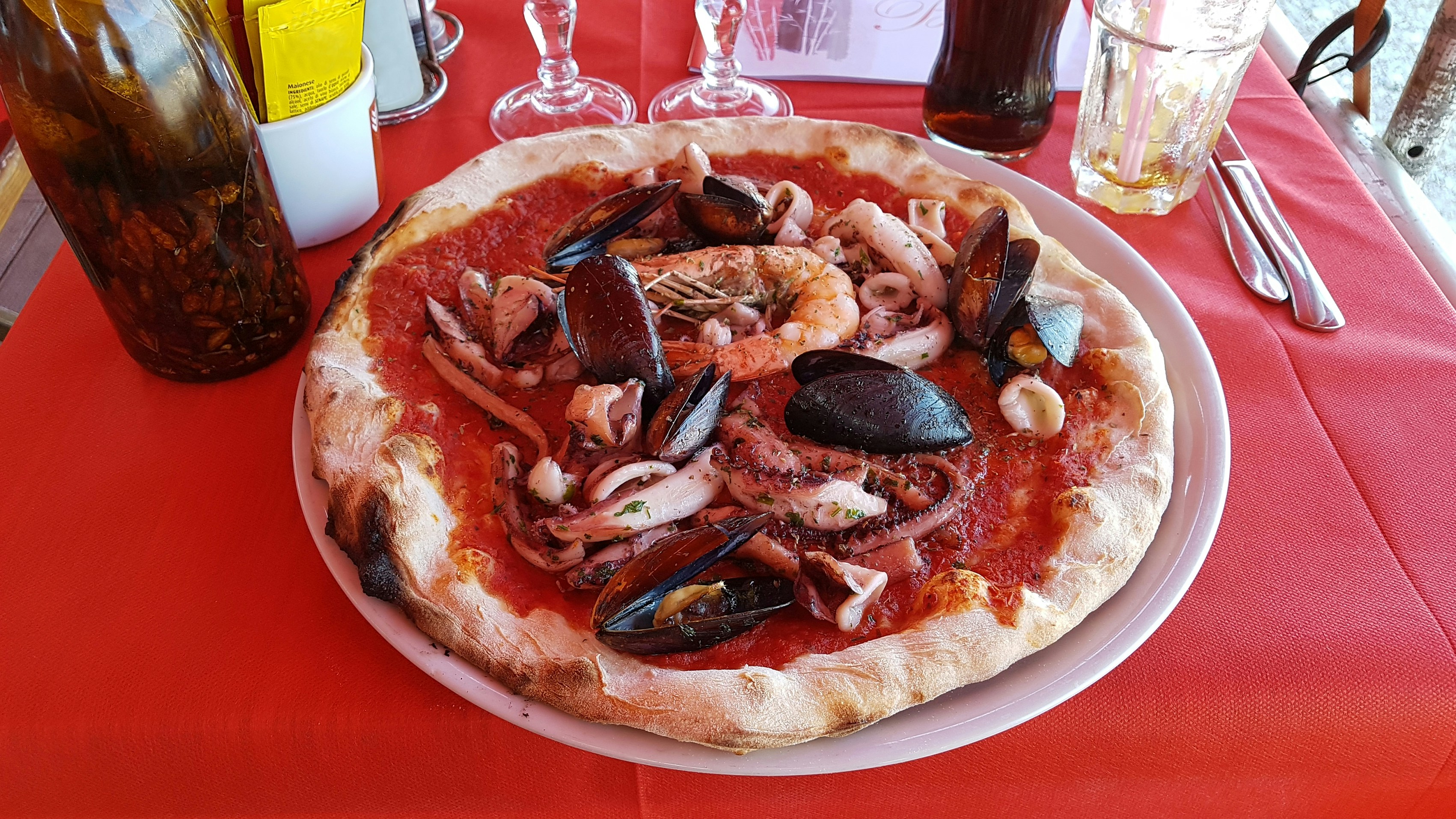 Pizza ai frutti di mare con cozze, vongole e gamberi su sfondo scuro