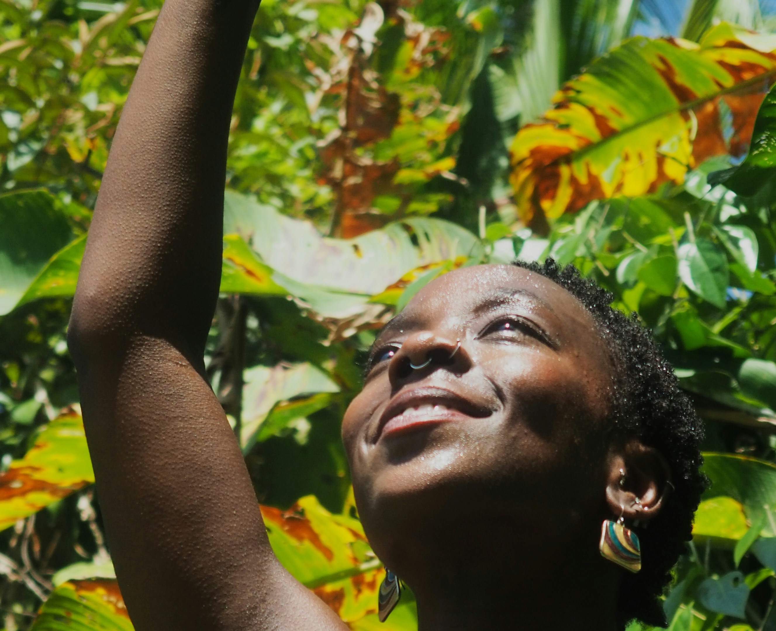a woman reaching up into the air to catch a frisbee
