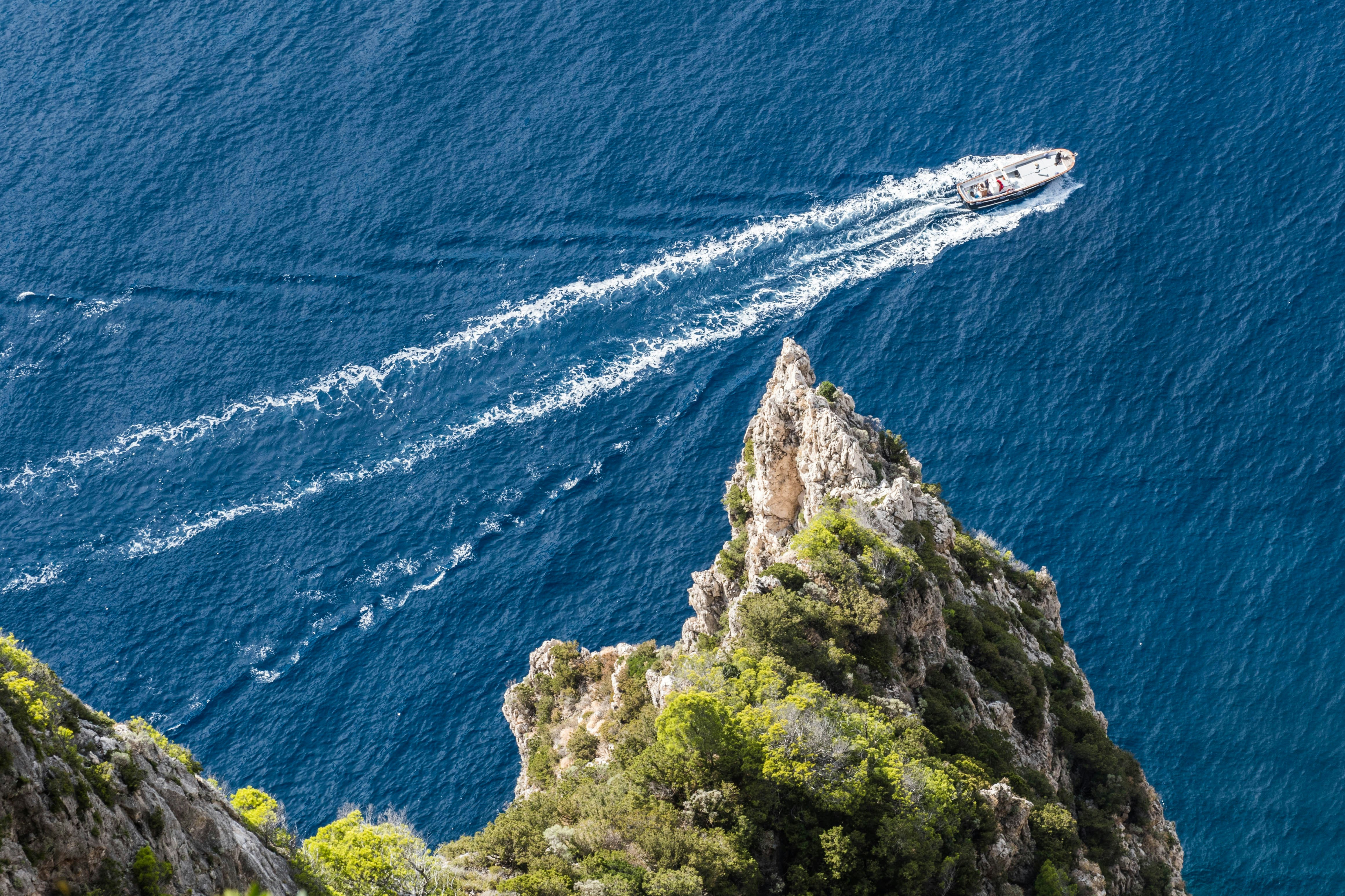 a boat traveling on the water near a mountain