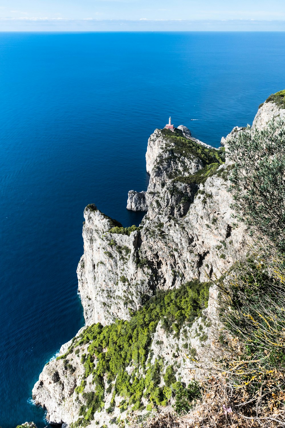 a person standing on top of a cliff next to the ocean
