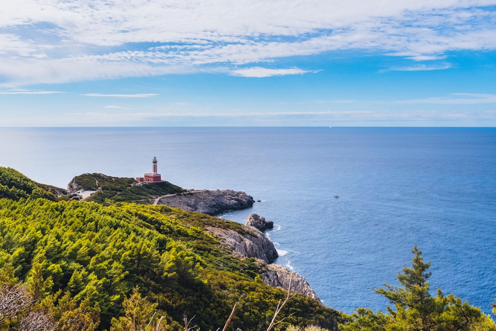 a lighthouse on top of a hill near the ocean