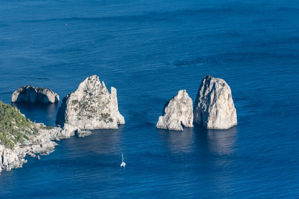 A group of rocks sitting in the middle of a body of water — Capri, Italy