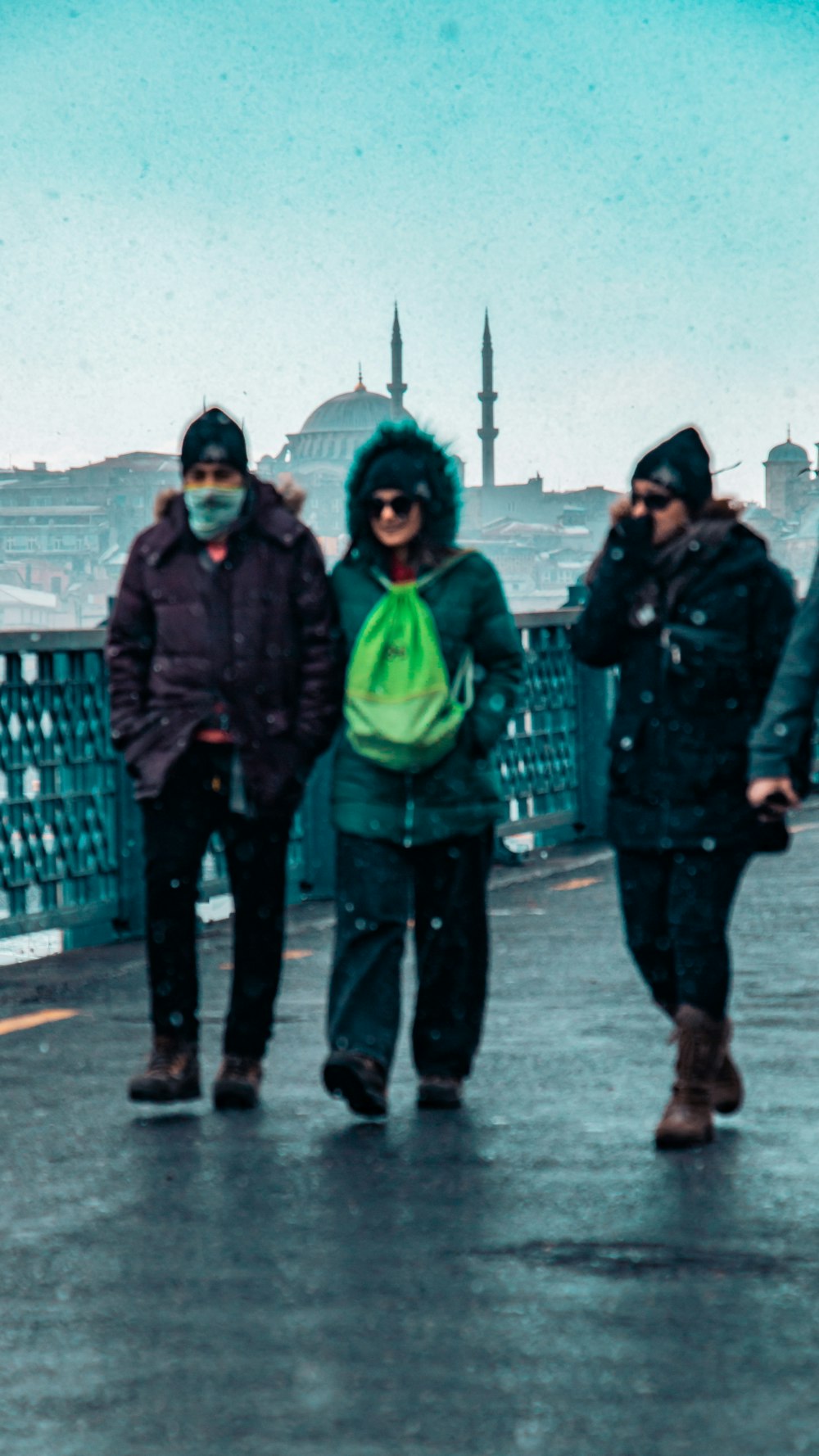 a group of people walking across a bridge