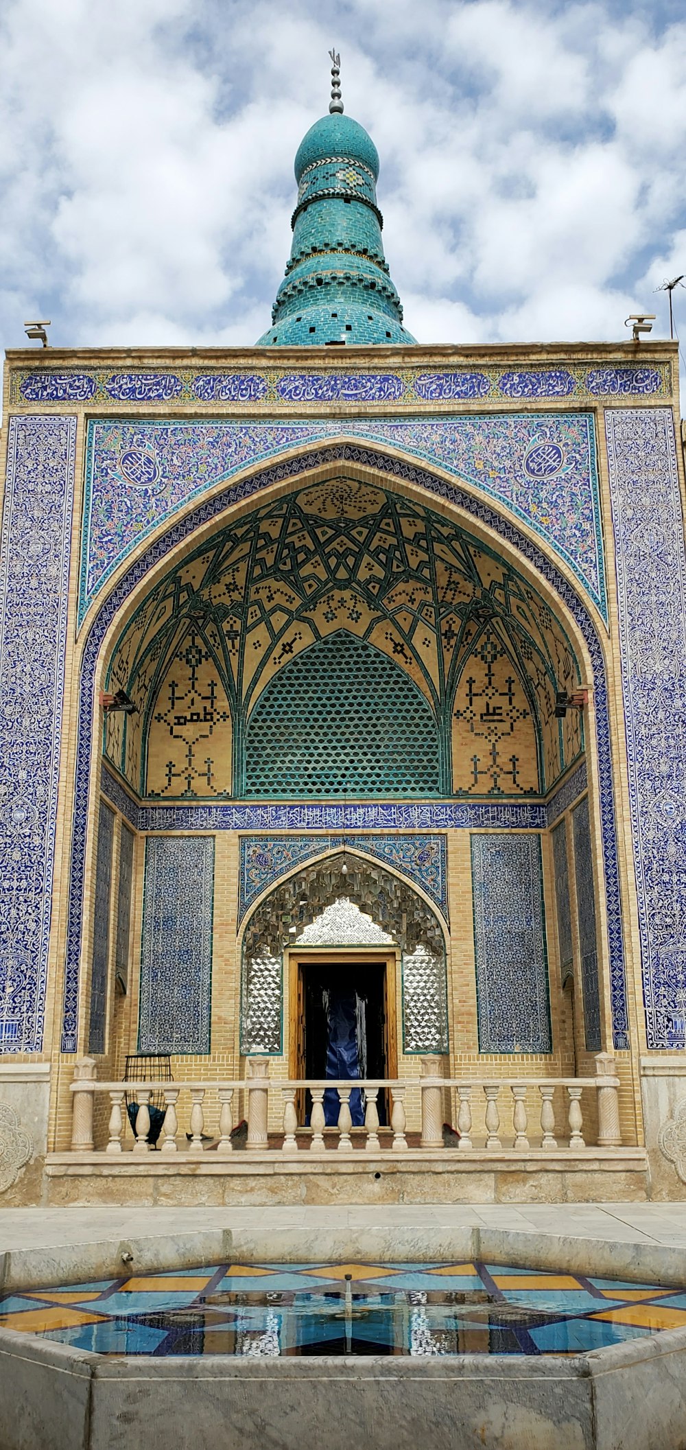 a blue and gold building with a fountain in front of it