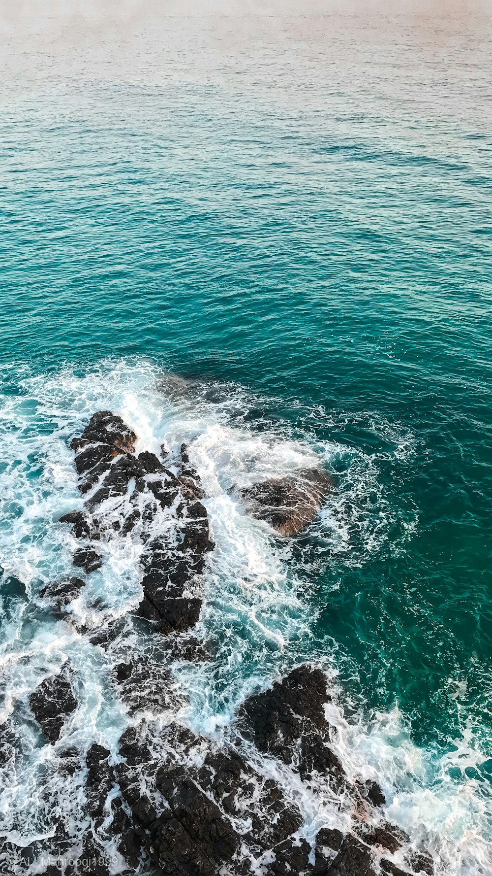 a view of a body of water with rocks in the foreground