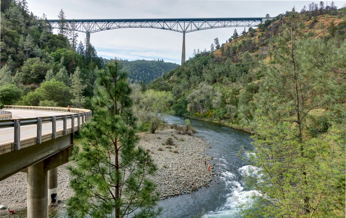 A tall steel bridge across a river canyon in the Auburn State Recreation Area, seen from a lower road bridge