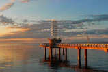 A sleek, modern pier extending over calm water at sunset, highlighting craftsmanship.