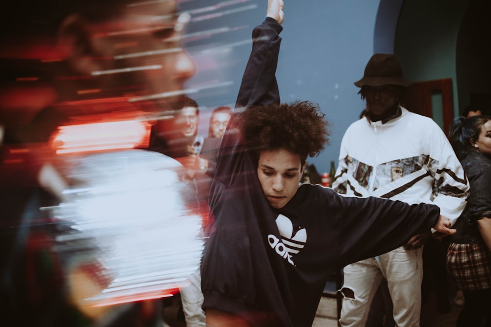 a young man is dancing in front of a group of people